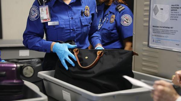 A Transportation Security Administration worker screens luggage at New York